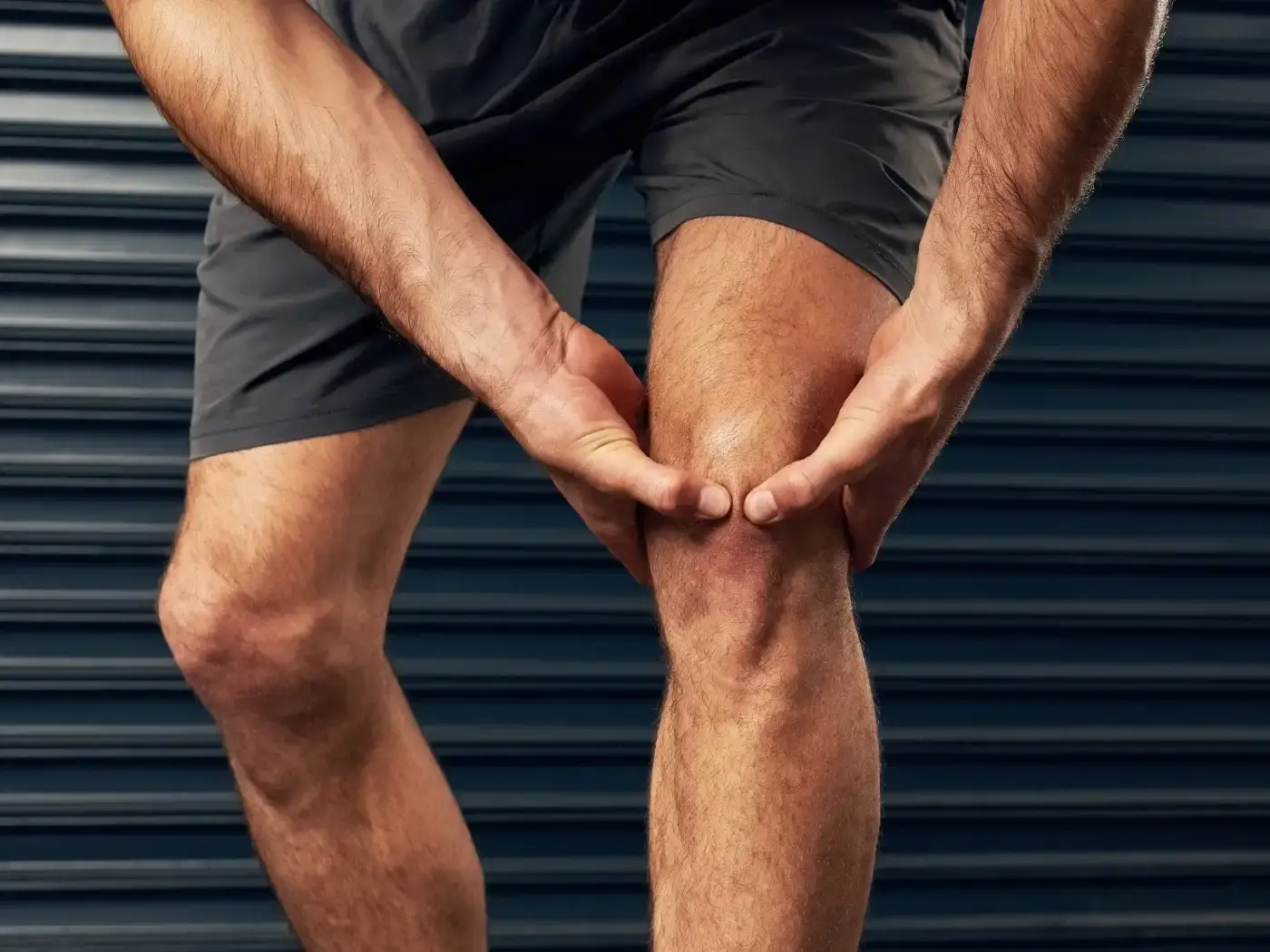 ACL Tear - man touching knee